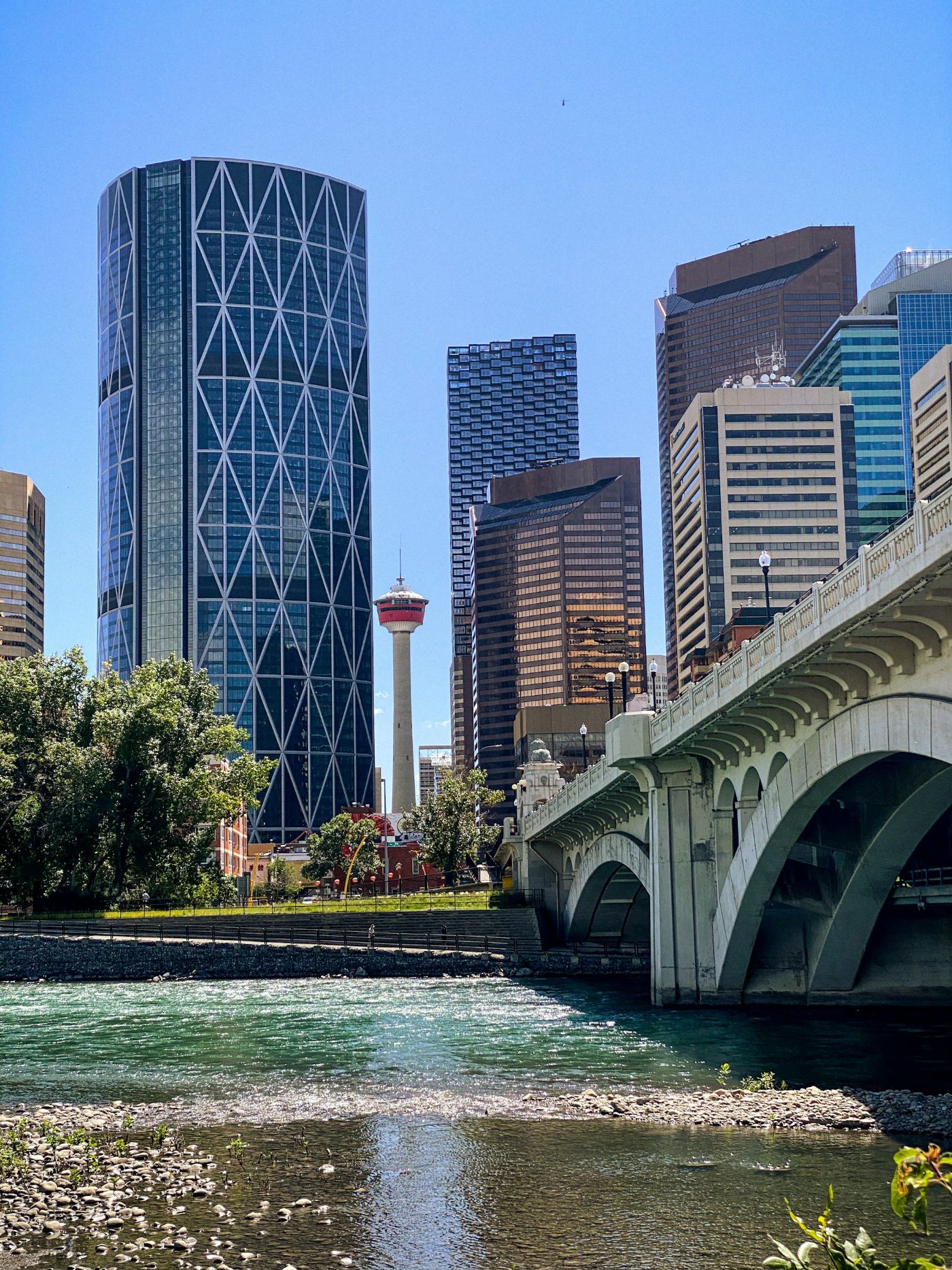 The Centre Street Bridge over the Bow River, with the Calgary Tower and downtown office buildings behind it on a clear summer day.